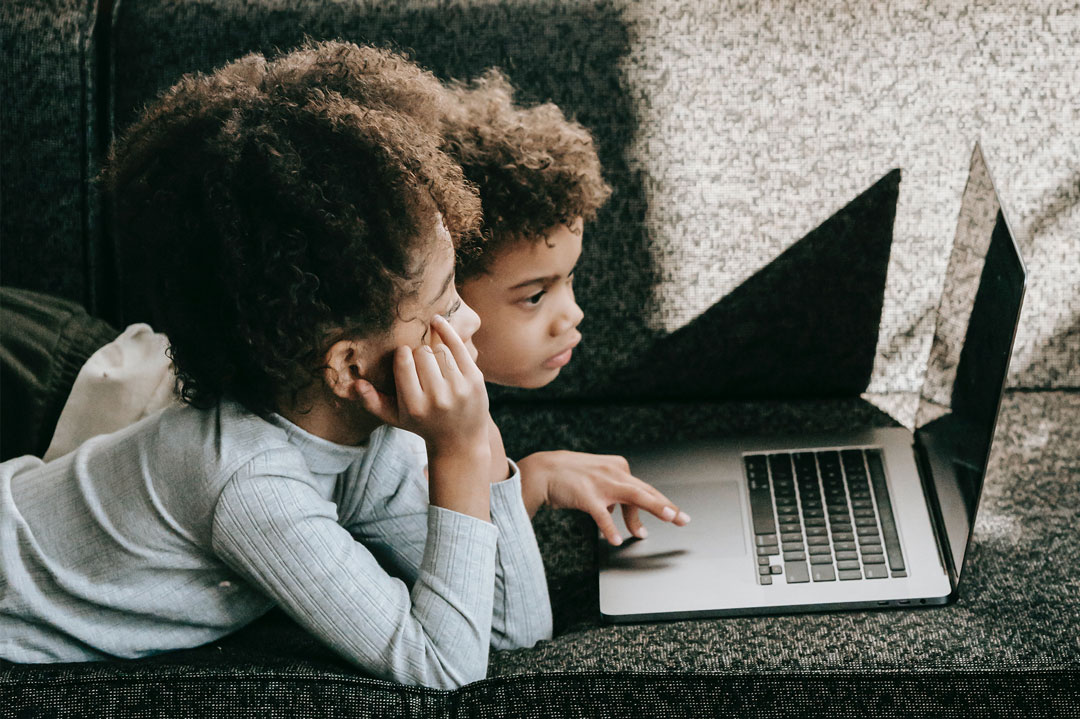 Two children looking at a laptop