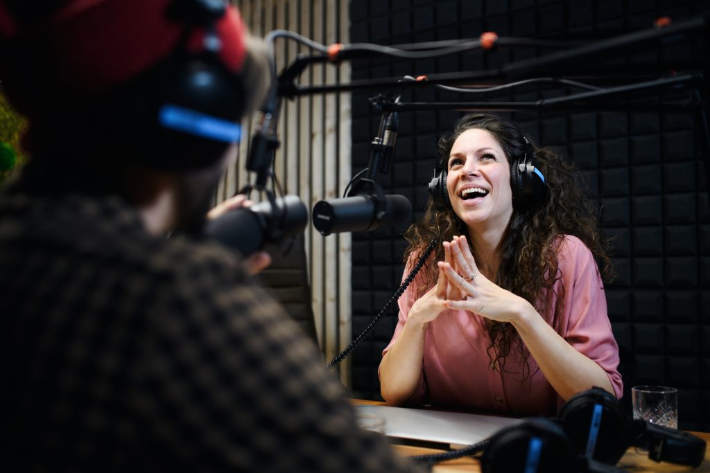 Young woman and man makes a podcast audio recording in a studio.