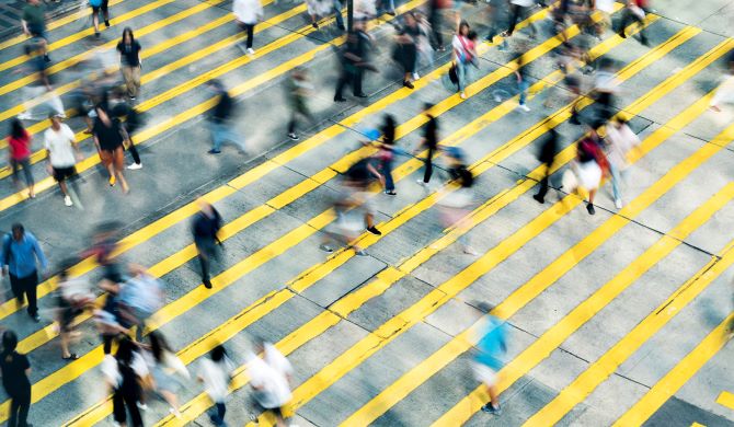 Blurred people walking across yellow crossing